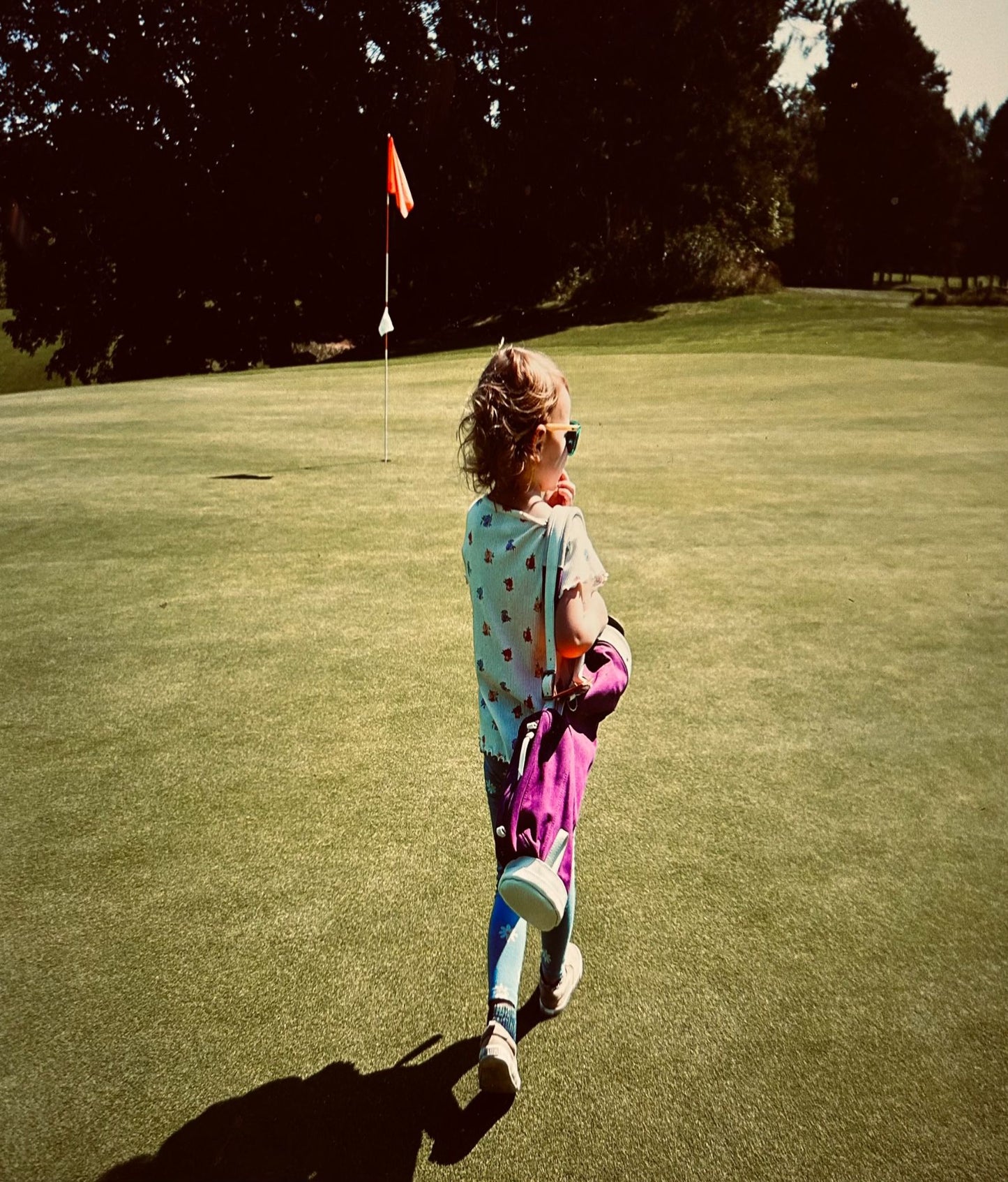 kid carrying a kids golf bag