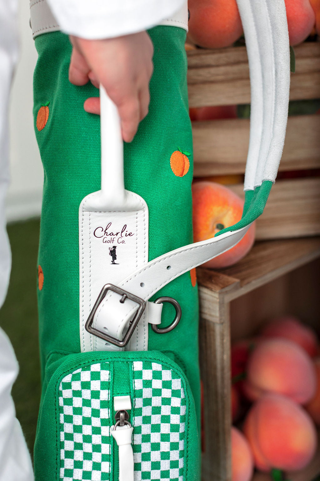 boy holding onto handle of junior golf bag