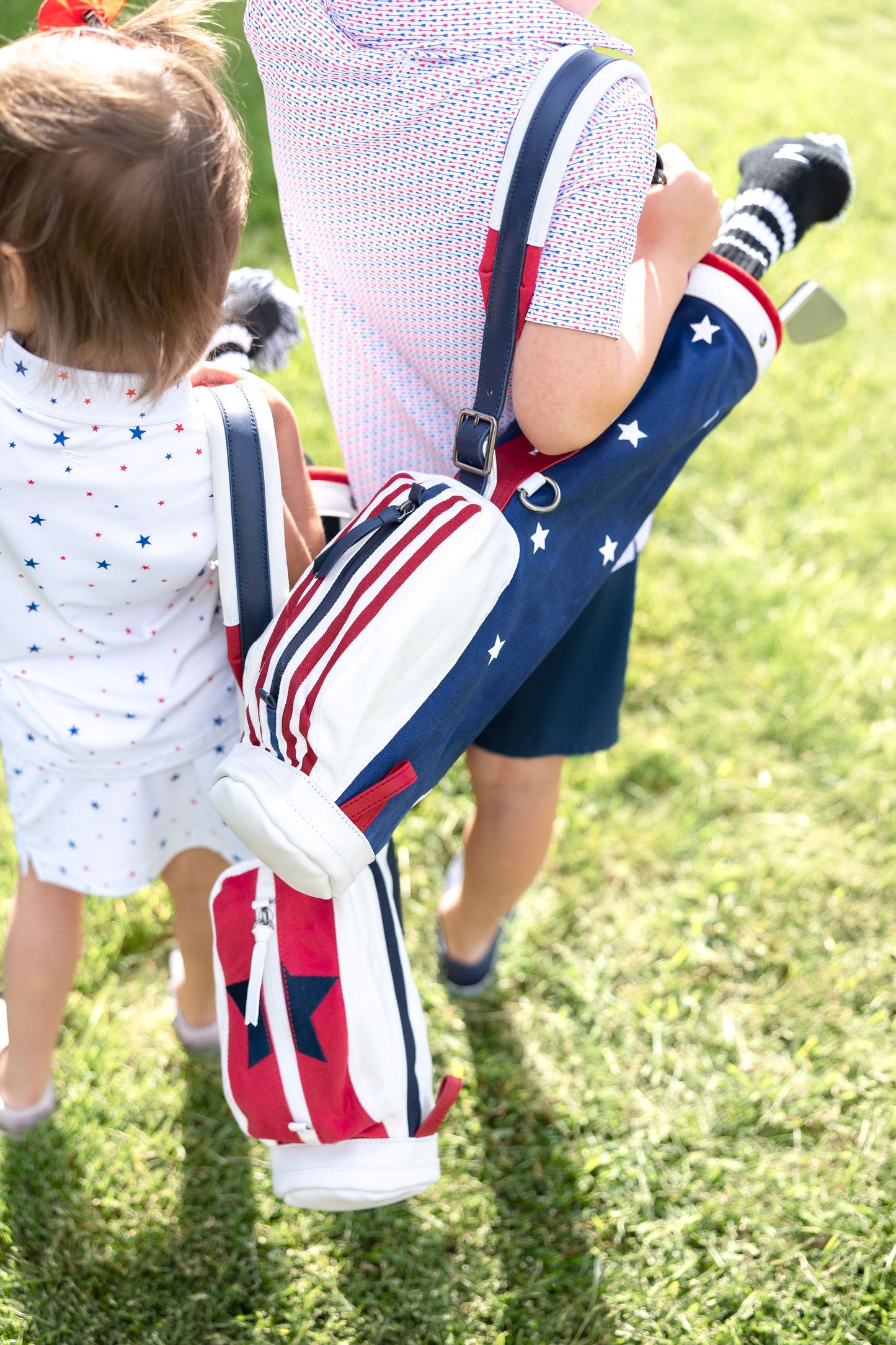 kids holding toddler golf bag with kids golf clubs inside