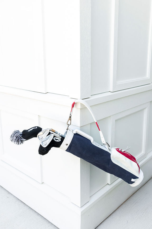 kids golf clubs hanging in red white and blue golf bag for kids