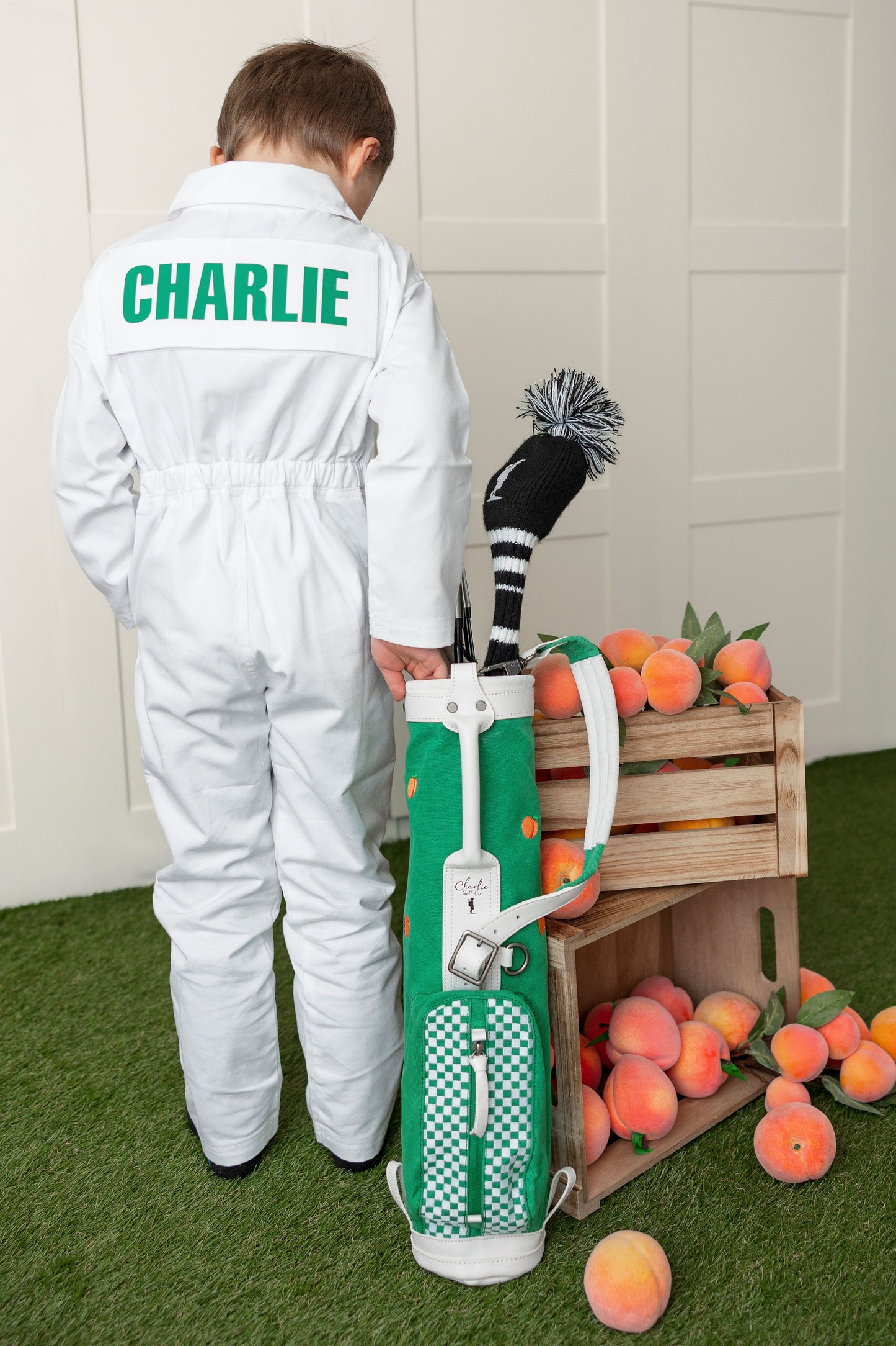 boy standing next to kid golf set 