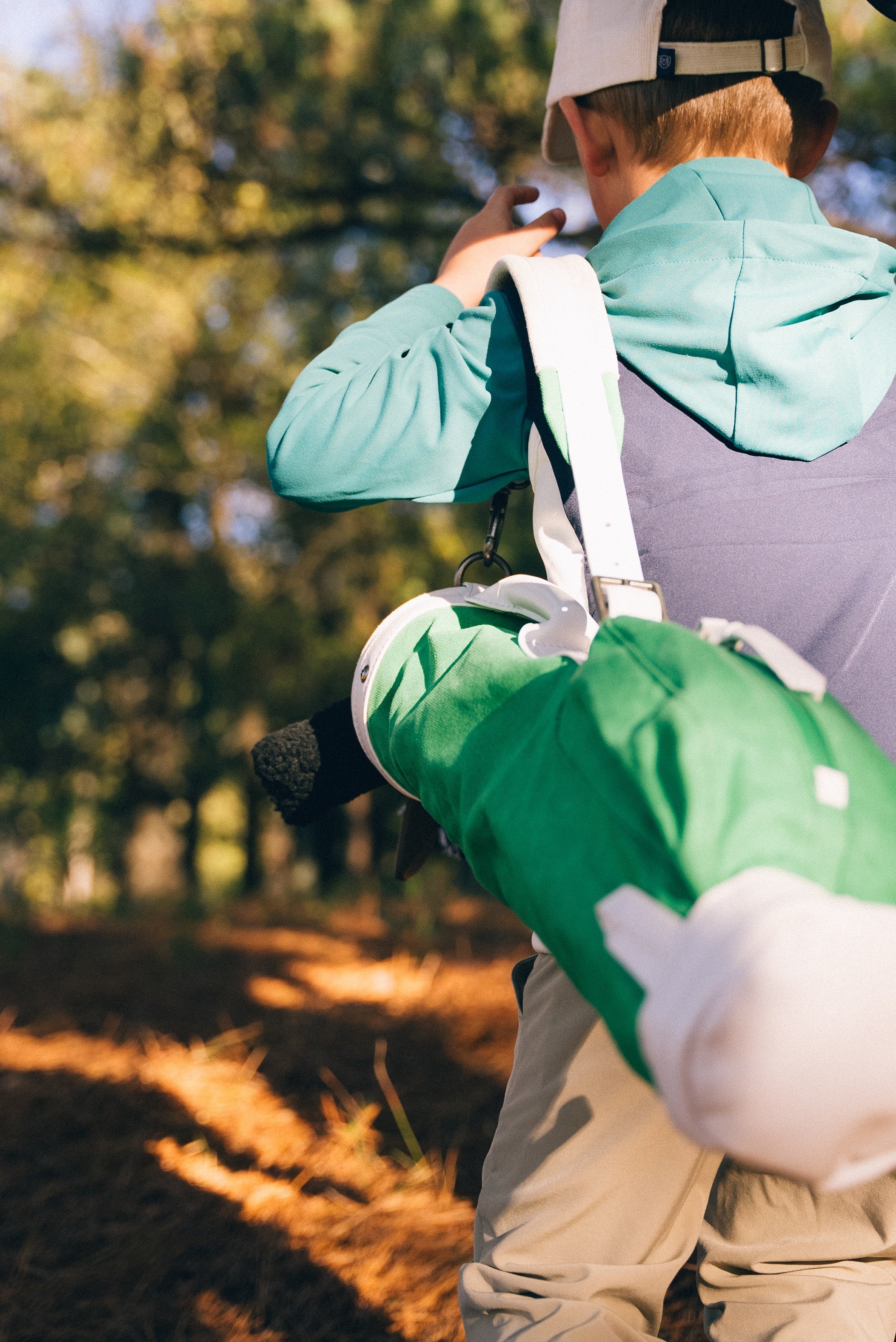 kid carrying golf bag