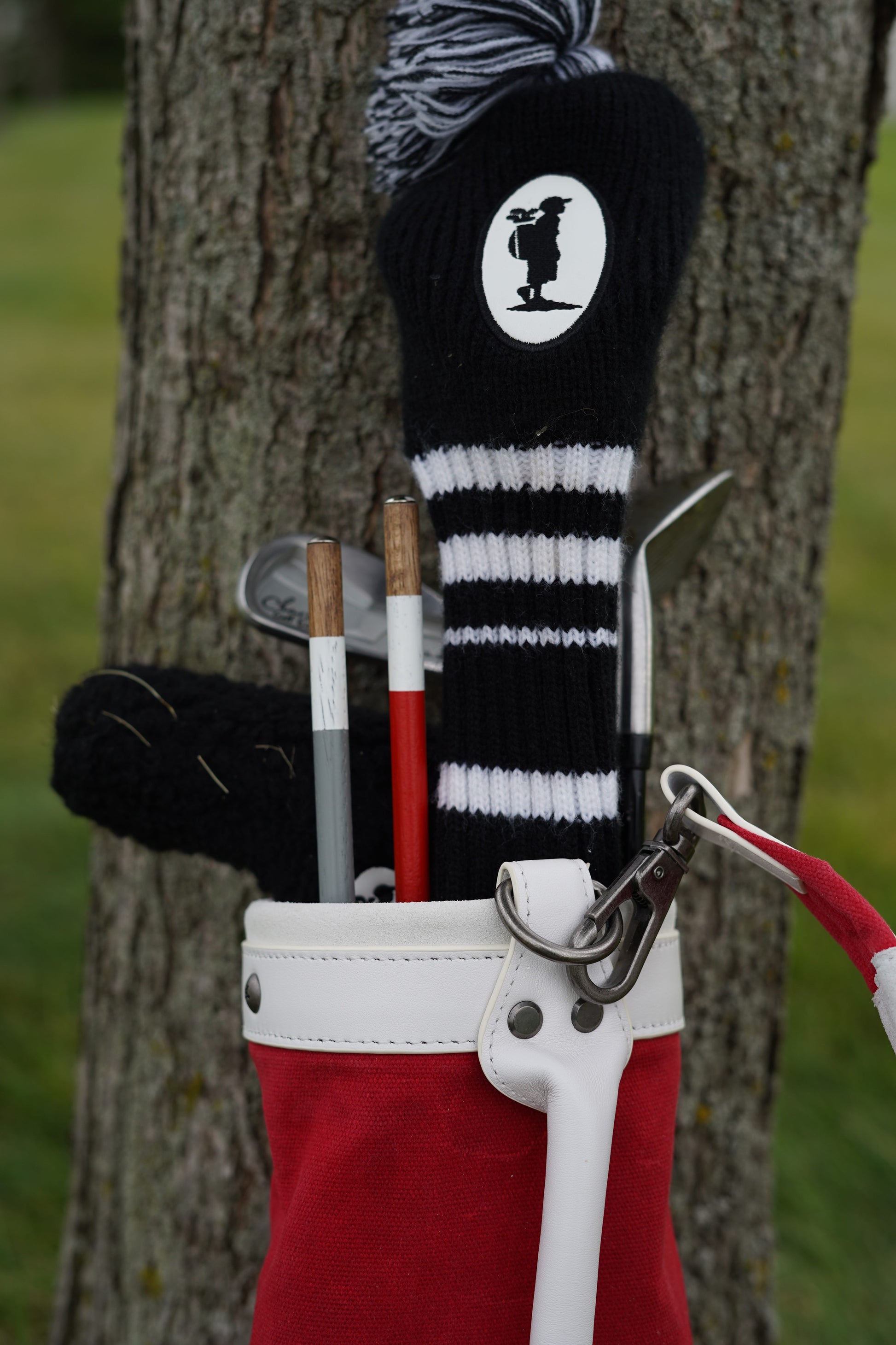 red kids golf bag with kids golf clubs and alignment stick