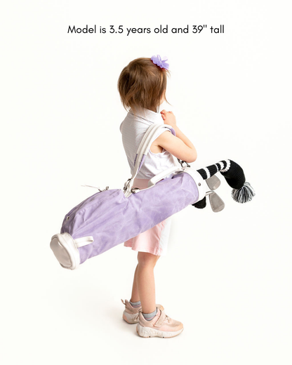 girl carrying a toddler golf bag with kids golf clubs
